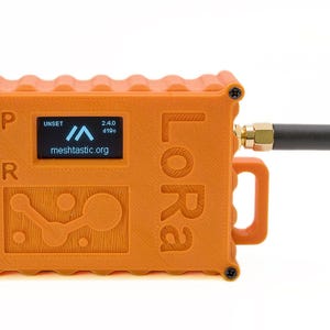 May include: Orange LoRa device with a black antenna and a small screen displaying "meshstatic.org". The device has buttons labeled "P" and "R" and a handle. The word "LoRa" is printed on the side.