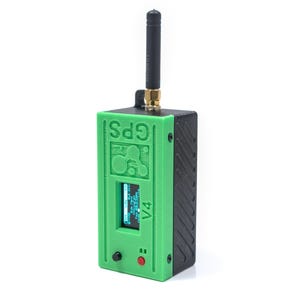 May include: A black and green GPS device with a screen displaying data. The device has a black antenna and a green front panel with the text "GPS V4". A red button and a black button are visible on the front.