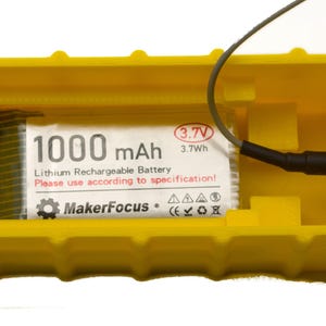 May include: A yellow plastic case with a 1000 mAh lithium rechargeable battery inside. The battery is labeled "MakerFocus" and has a 3.7V, 3.7Wh rating. The case has a connector on the side.