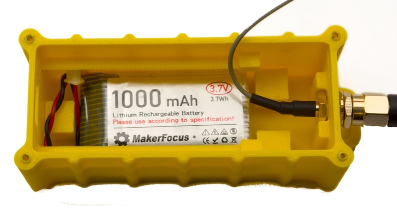 May include: A yellow plastic case with a 1000 mAh lithium rechargeable battery inside. The battery is labeled "MakerFocus" and has a 3.7V, 3.7Wh rating. The case has a connector on the side.