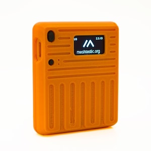 Peut inclure: Dispositif de réseau maillé orange avec un écran bleu affichant le texte "meshtactic.org" et l'heure "2.3.13".