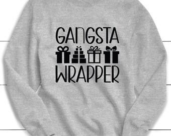 May include: A gray sweatshirt with the text "Gangsta Wrapper" in black lettering. The text is surrounded by a graphic of four gift boxes with bows.