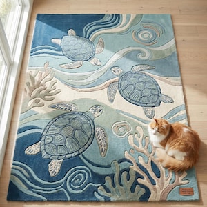 May include: A rectangular area rug featuring a blue and beige ocean-themed pattern with three sea turtles, coral formations, and swirling water currents. The rug has a textured surface and a small rectangular label in the corner with printed text.