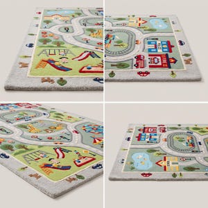 May include: A rectangular area rug featuring a light grey border and a colourful play mat design. The surface displays a town scene with roads, a train track, a school, a police station, a fire station, a zoo, a playground, and a pond.