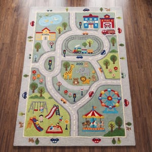 May include: A rectangular area rug featuring a colourful city map design with roads, a train track, a zoo with animals, a playground, a ferris wheel, and a carousel. Buildings labelled School, Police, and Fire are depicted alongside a pond.
