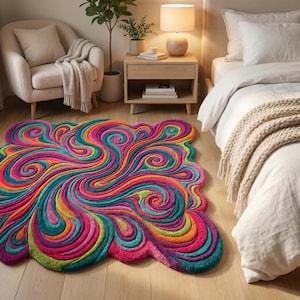 Peut inclure: Un tapis color&eacute; avec un motif abstrait et tourbillonnant. Le tapis pr&eacute;sente des nuances de rose, de sarcelle, d'orange et de vert, cr&eacute;ant un motif dynamique. Le tapis mesure environ 152 cm sur 183 cm.