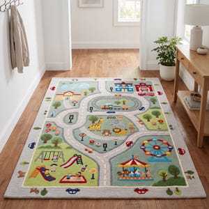 May include: A rectangular area rug featuring a colourful town map design with roads, a train track, a zoo with animals, a playground, a carousel, and a Ferris wheel. The rug includes buildings labelled School, Police, and Fire, set on a light green background.