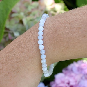 May include: A white gemstone bracelet with round beads. The bracelet is made of natural stones and is a beautiful accessory for any occasion.