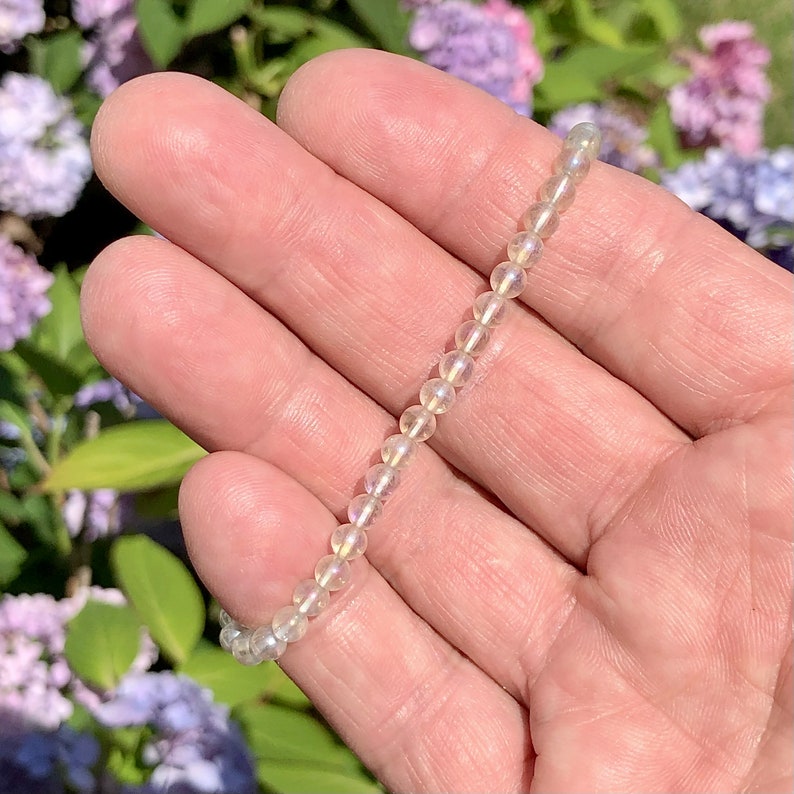 May include: A white iridescent labradorite gemstone bracelet with round beads.