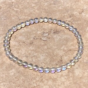 May include: A white iridescent labradorite gemstone bracelet with round beads.