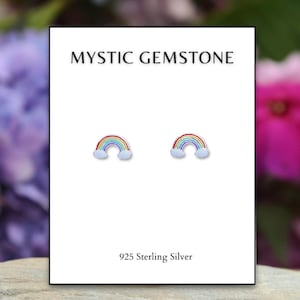 May include: A pair of sterling silver rainbow earrings with clouds. The earrings are on a white card with the text "MYSTIC GEMSTONE" and "925 Sterling Silver".