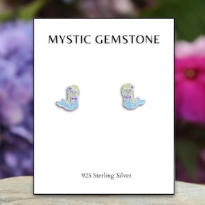 May include: A pair of sterling silver earrings featuring a small, colorful mermaid design. The earrings are on a white card with the text "MYSTIC GEMSTONE" and "925 Sterling Silver".
