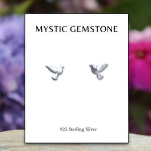 May include: A pair of sterling silver dove earrings on a white card with the text "Mystic Gemstone" and "925 Sterling Silver".