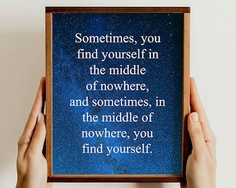 May include: A framed print with a blue starry night background and white text that reads: "Sometimes, you find yourself in the middle of nowhere, and sometimes, in the middle of nowhere, you find yourself."