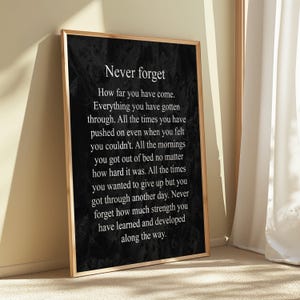 May include: Black and white inspirational quote poster with the text "Never forget" and a message about perseverance and growth. The poster has a textured background.