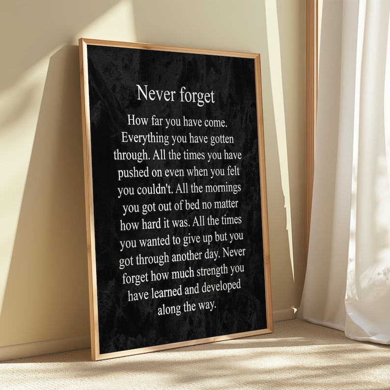 May include: Black and white inspirational quote poster with the text "Never forget" and a message about perseverance and growth. The poster has a textured background.