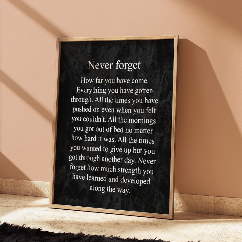 May include: Black and white inspirational quote print with the text "Never forget" and a message about perseverance and growth. The quote is printed on a textured background.
