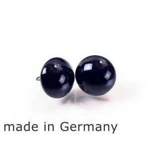 Op de afbeelding: Een paar zwarte oorbel studs. De oorbellen zijn rond en hebben een gladde, glanzende afwerking. De oorbellen zijn gemaakt in Duitsland.