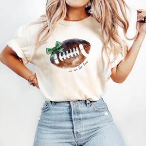 Unisex Football Mom T-Shirt with Coquette Mascot Bow, Custom School Spirit Tee, Cheer Mascot Football Team Shirt, Sports Mom Gift
