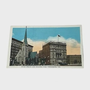 May include: Vintage postcard featuring Christ Church and Columbia Club in Indianapolis, Indiana. The image showcases a detailed illustration of the church with a tall steeple and the club building, set against a blue sky with clouds. The text "Christ Church and Columbia Club, Indianapolis, Ind." is printed at the bottom.
