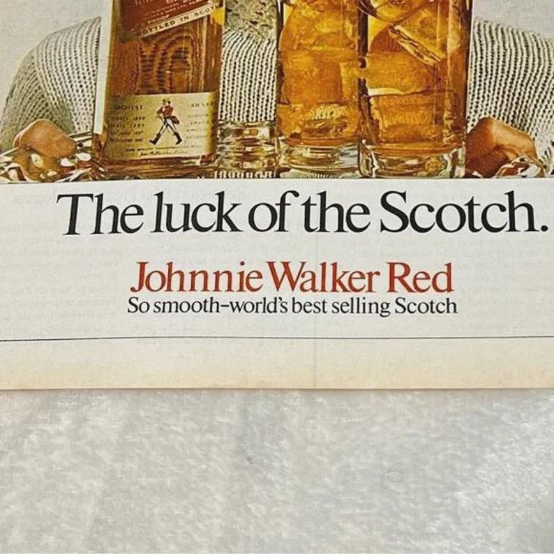 May include: An advertisement for Johnnie Walker Red Scotch. The image features a bottle of scotch, two glasses of scotch on the rocks, and the text "The luck of the Scotch." The text "Johnnie Walker Red" is also visible, along with the tagline "So smooth-world's best selling Scotch."
