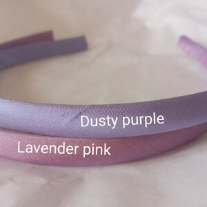 May include: Two fabric headbands, one dusty purple and one lavender pink.