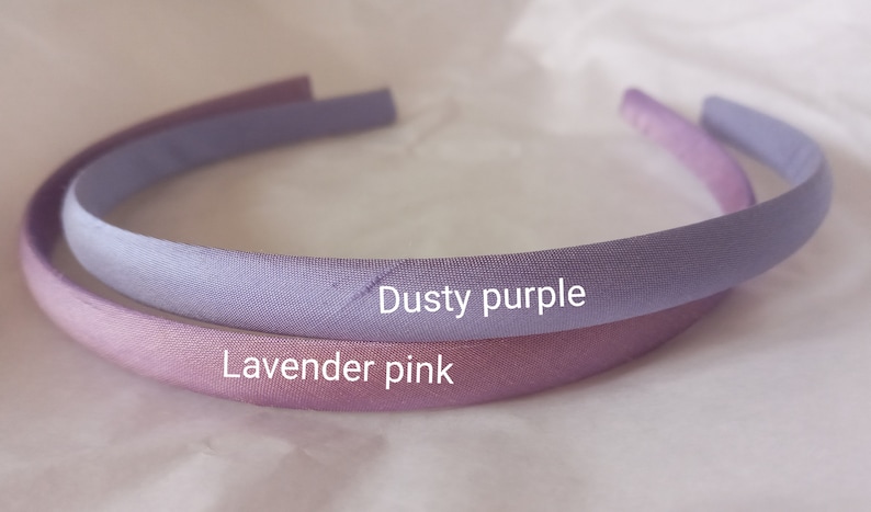 May include: Two fabric headbands, one dusty purple and one lavender pink.