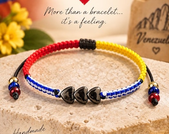 May include: A macrame bracelet featuring a woven pattern in yellow, blue, and red, accented with three central black heart-shaped beads. The adjustable cord ends are finished with small gold, blue, and red beads, creating a vibrant accessory.