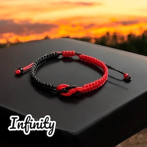 Puede incluir: Pulsera de nudo infinito rojo y negro. La pulsera está hecha de cordón trenzado y tiene un diseño de nudo simple.