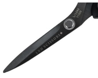 May include: Close-up of black scissors with the text "LDH SCISSORS" and "Y1508" printed on the blades. The scissors have a sleek, modern design, with a silver rivet and a small maple leaf symbol.