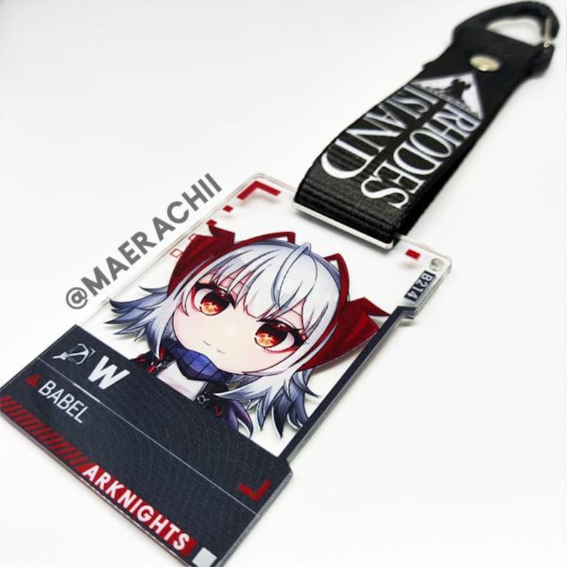 May include: A clear acrylic keychain featuring a cartoon character with white hair and red accents. The keychain has a black and red design with the text "ARKNIGHTS" and "BABEL". A black strap with "RHODES ISLAND" is attached.