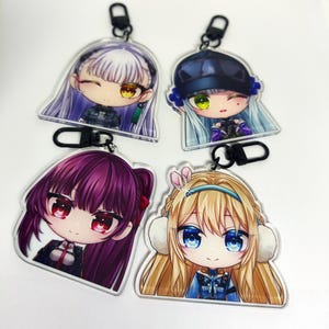 May include: Four anime-style character keychains. Each keychain features a different character with large eyes, unique hairstyles, and outfits. The keychains are made of clear acrylic and have black metal clasps.