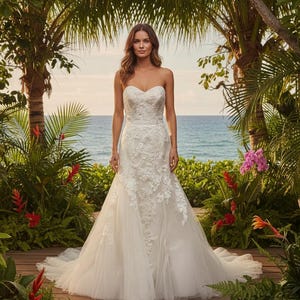 May include: A strapless ivory wedding dress featuring a sweetheart neckline and a fitted bodice adorned with intricate white floral lace appliqués that extend down into a full, layered tulle skirt with a sweeping train.