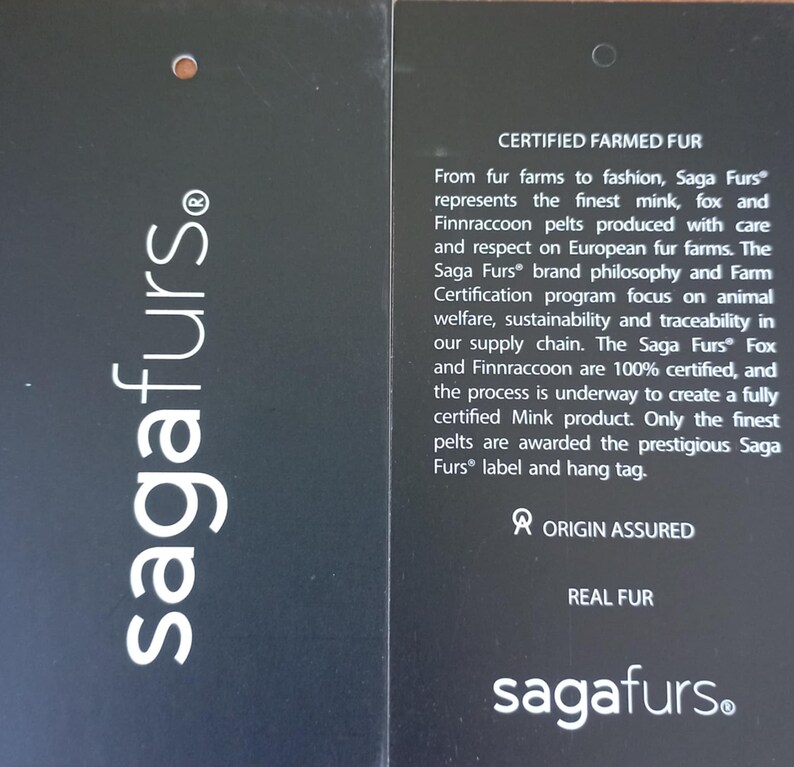 May include: A black and white label with the text "sagafurs." and "CERTIFIED FARMED FUR." The label explains that Saga Furs&reg; represents the finest mink, fox, and Finnraccoon pelts produced with care and respect on European fur farms. The label also states that the Saga Furs&reg; brand philosophy and Farm Certification program focus on animal welfare, sustainability, and traceability in the supply chain.