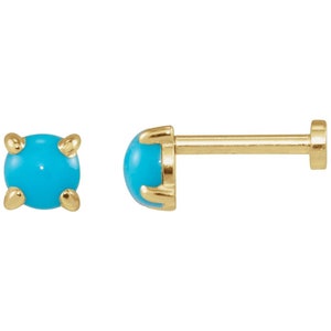 May include: A pair of gold-toned turquoise gemstone earrings. The earrings are small and round, with a prong setting. The turquoise stones are a vibrant blue color.