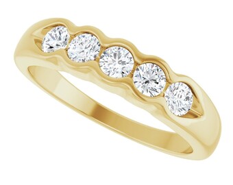 May include: A gold band with five round diamonds set in a wavy design.