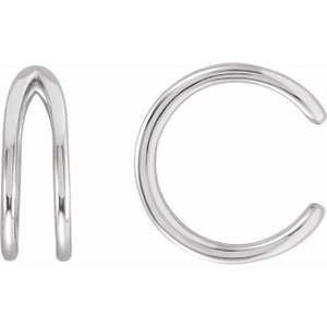May include: A pair of silver ear cuffs. The ear cuff on the left is a double loop design. The ear cuff on the right is a single loop design.