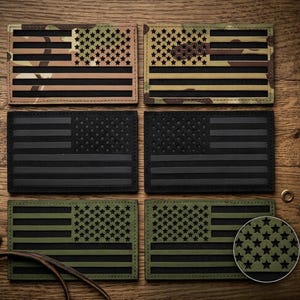 May include: A collection of rectangular patches featuring the American flag design. The patches come in various color schemes, including camouflage, black, and olive green. Each patch has the stars and stripes design.