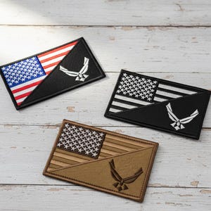 May include: Three rectangular patches featuring the American flag and the Air Force symbol. One patch has a red, white, and blue flag design, while the other two have black and white flag designs. The Air Force symbol is white.