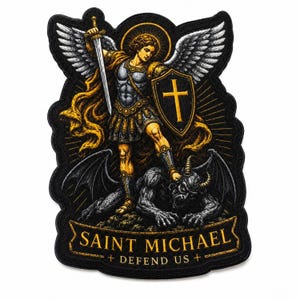 May include: An embroidered patch featuring Saint Michael with wings, holding a sword and a shield with a cross, standing over a demon. The design uses black, gold, and white thread. A banner at the bottom reads SAINT MICHAEL + DEFEND US +.