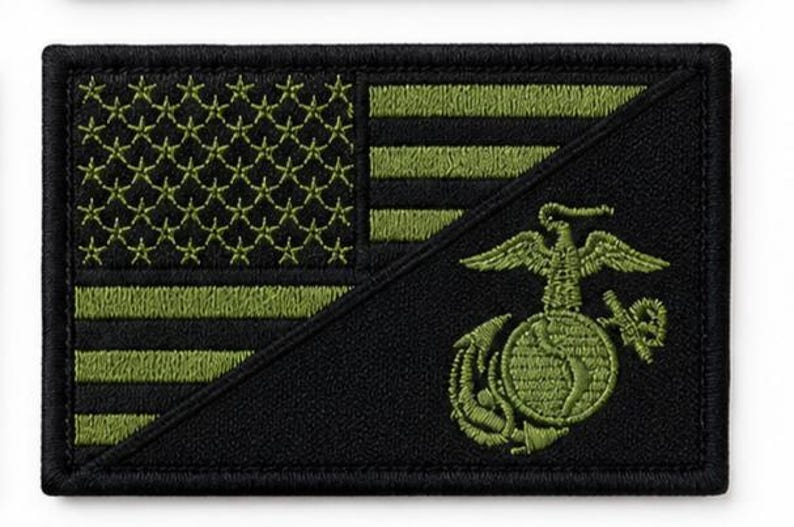May include: A rectangular embroidered patch featuring a black and olive green American flag design. The lower right section displays the United States Marine Corps Eagle, Globe, and Anchor emblem in olive green thread against a solid black background.
