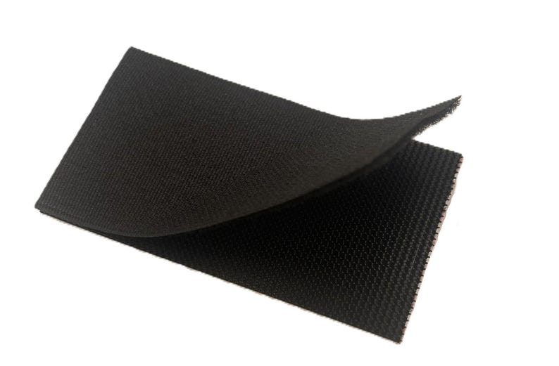 May include: A rectangular piece of black hook and loop fastener material. The top layer is folded back to reveal the textured, woven surface of the fabric. The material has a consistent dark black color and a uniform, fine-grained grid pattern.