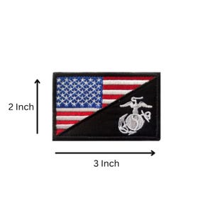 May include: A rectangular embroidered patch featuring a split design with the American flag on the upper left and a black background with a white United States Marine Corps emblem on the lower right. The patch measures 2 inches by 3 inches.