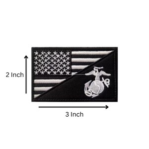 May include: A rectangular embroidered patch featuring a black and white American flag design split diagonally with the United States Marine Corps Eagle, Globe, and Anchor emblem. The patch measures 2 inches in height and 3 inches in width.