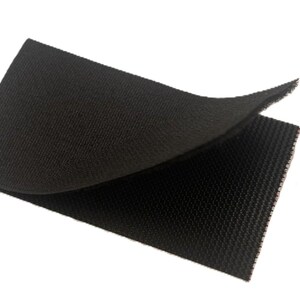 Pode incluir: Duas pe&ccedil;as de material de fixa&ccedil;&atilde;o de velcro preto, uma ligeiramente levantada para revelar a superf&iacute;cie texturizada. O material &eacute; de cor preta escura e lisa, e as bordas s&atilde;o limpas e retas. O fundo &eacute; branco liso.