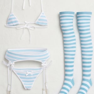 Könnte beinhalten: Hellblau-weiß gestreiftes Dessous-Set, bestehend aus einem Triangel-Bikini-Oberteil, einem hoch taillierten Strumpfhaltergürtel, einem String-Tanga und zwei Oberschenkelstrümpfen. Das Set ist mit weißen Bändern gebunden.