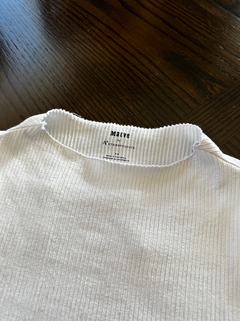 K&ouml;nnte beinhalten: Wei&szlig;es, geripptes Langarmshirt mit einem schwarzen Etikett mit der Aufschrift "Maeve by Anthropologie" und "Gr&ouml;&szlig;e S".