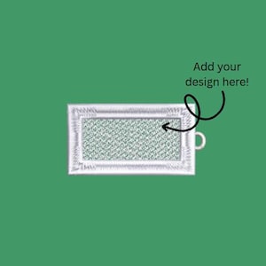 May include: A rectangular patch with a white embroidered border and a light green center. The text "Add your design here!" is written in black. The patch has a small loop on the right side.