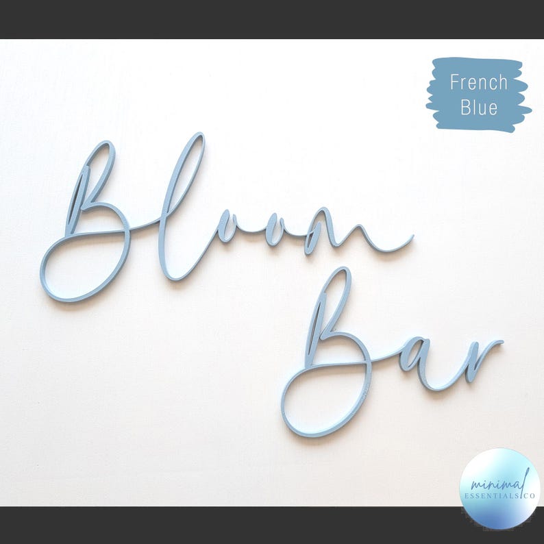 Bloom Bar wood sign cut from 1/4" plywood shown on a concrete background painted in french blue