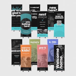 May include: A collection of vertical retractable banners for Freedom Church featuring black, white, and teal colour schemes with various text including New Here, You Belong Here, Next Steps, Welcome Kids, Nursery, Pre-K, K-5th, and Welcome Home.